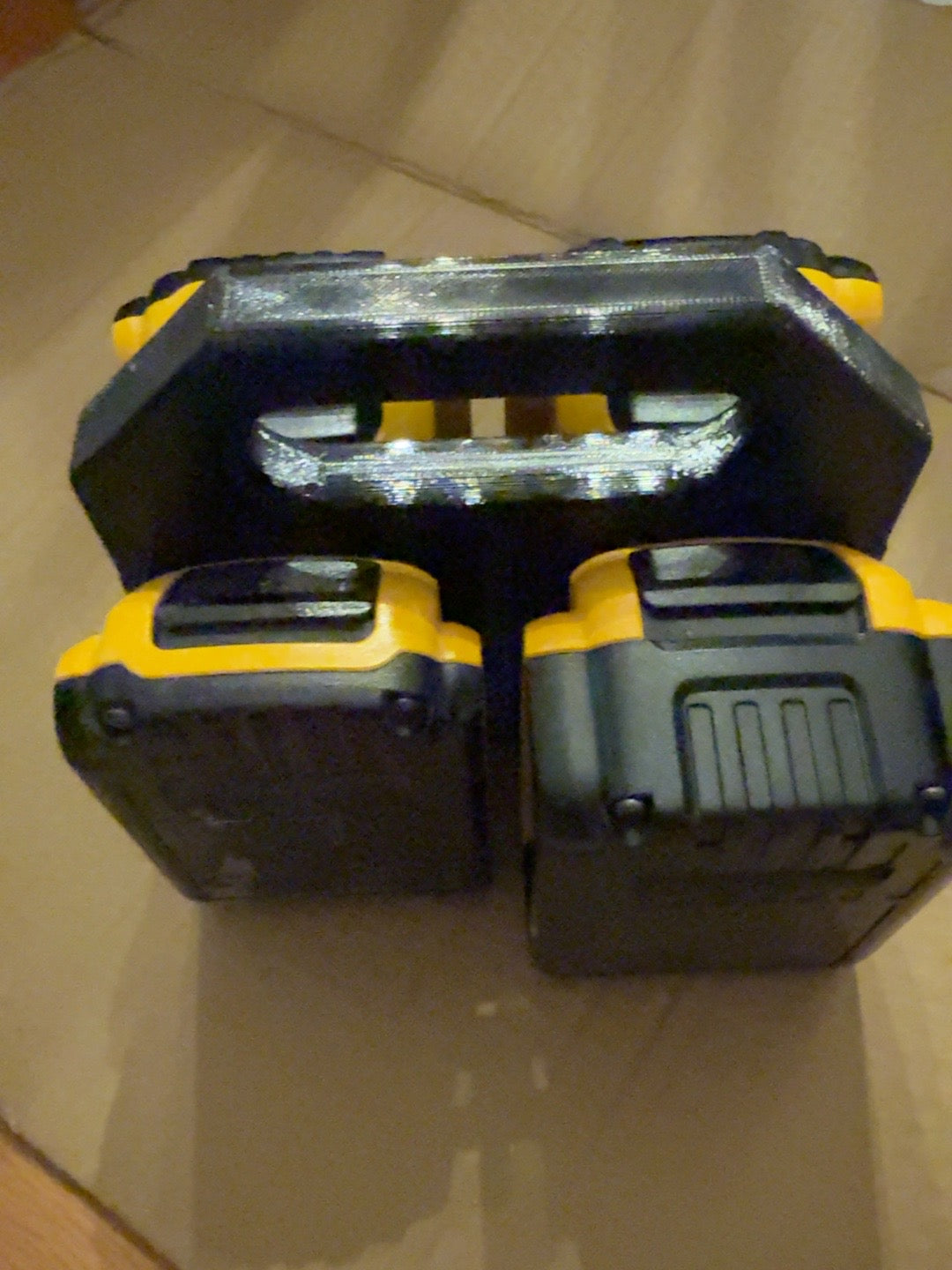 Black PETG four-battery caddy compatible with DEWALT 20V MAX-style batteries, loaded with four batteries, side view